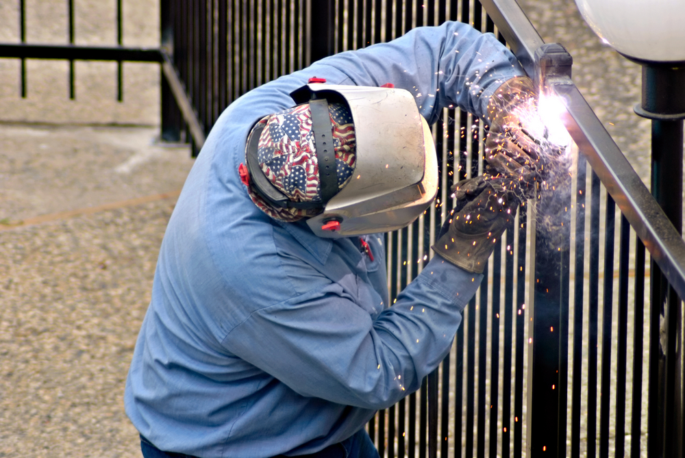 man welding metal fence